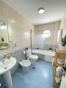 a bathroom with two toilets and a sink and a tub at Apartamento Baluarte in Sanlúcar de Barrameda