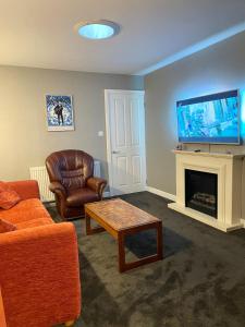 a living room with a couch and a tv at Two bedroom detached bungalow with conservatory in Bottesford