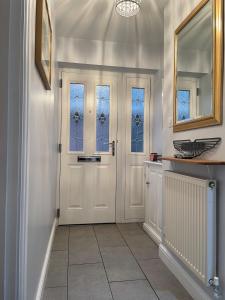 a hallway with a white door and windows at Two bedroom detached bungalow with conservatory in Bottesford +15 photos