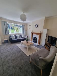 a living room with a couch and a fireplace at Blossom House in Woodbridge