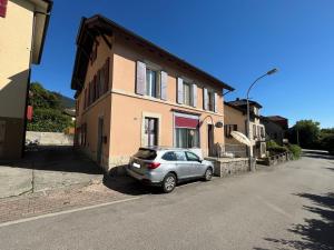 a silver car parked in front of a house at Loc Aquatropic appartement de vacances in Bevaix
