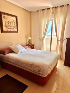 a bedroom with a bed and a large window at Exclusive Penthouse Pool & Beach - Lovely for families - Los Pinos Residential in El Campello +13 photos