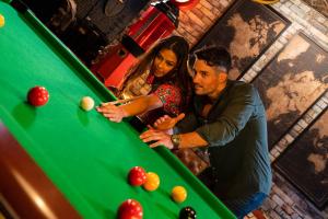 a man and a woman standing next to a pool table at Le Speakeazy in Petite Île