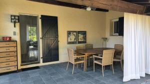 una sala da pranzo con tavolo e sedie in legno di Le Paradis de l'Ibie a Saint-Maurice-dʼIbie