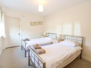 two beds in a room with white walls at Swallow Barn in Halesworth +21 photos