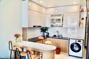 een keuken met witte kasten en een wasmachine bij Si Mơ Homestay Cát Bà in Cat Ba +7 foto's