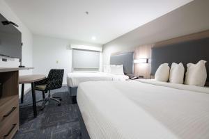 a hotel room with two beds and a desk at Best Western Lafayette Inn in Lafayette