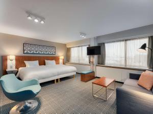 a hotel room with a bed and a couch at Radisson Blu Hotel Olümpia in Tallinn