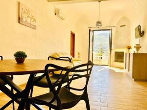 a dining room with a wooden table and chairs at Spazioso Appartamento da Maria in Favignana
