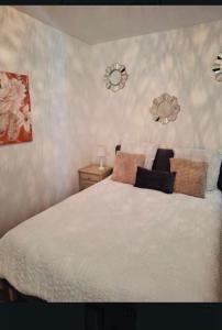 a bedroom with a white bed with pillows on it at Appartement 2-4 pers in Souillac
