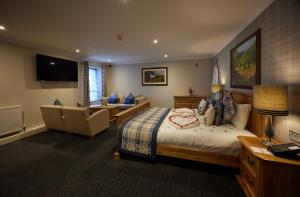 a hotel room with a bed and a living room at Stone House Hotel ‘A Bespoke Hotel’ in Stone