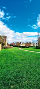 a field of green grass with houses in the background at Your 4 Bedroom Townhouse - Superking Bed in Stamford