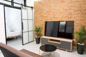 een woonkamer met een televisie en een bakstenen muur bij Moderno Piso Toledano in Toledo
