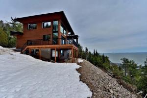 ein Haus auf einem schneebedeckten Hügel in der Unterkunft Villa St-Laurent et spa - Au coeur de Charlevoix ! in La Malbaie