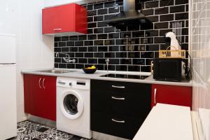een keuken met rode kasten en een wasmachine bij Moderno Piso Toledano in Toledo