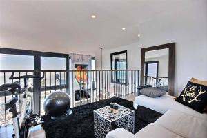 ein Wohnzimmer mit einem weißen Sofa und einem Balkon in der Unterkunft Villa St-Laurent et spa - Au coeur de Charlevoix ! in La Malbaie