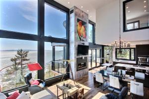 ein Wohnzimmer mit großen Fenstern und Meerblick in der Unterkunft Villa St-Laurent et spa - Au coeur de Charlevoix ! in La Malbaie