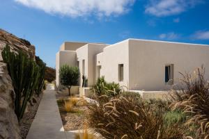 a row of white houses in the desert with plants at Wabi Luxury Suites & Maisonettes Ios in Ios Chora