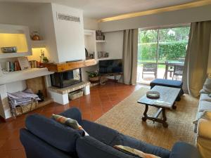 a living room with a blue couch and a fireplace at SOLAR DO GOLFE - Vilamoura in Vilamoura +41 photos