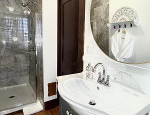a white bathroom with a sink and a mirror at Royal Hotel Sydney in Sydney