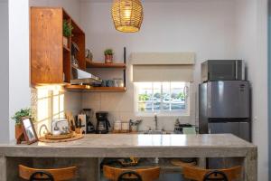 a kitchen with a counter with a sink and a refrigerator at Casa Bonita - Depa compacto 2 Habitaciones in Loreto