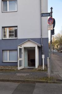 ein blau-weißes Gebäude mit offener Tür in der Unterkunft Aurora Apartment in Essen in Essen