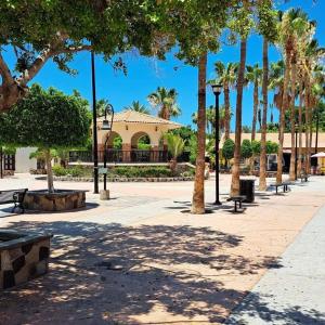 a park with palm trees and benches and a building at Casa Bonita - Depa compacto 2 Habitaciones in Loreto