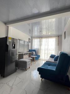 a living room with blue couches and a kitchen at Mirador M S Paipa 70m2 in Paipa