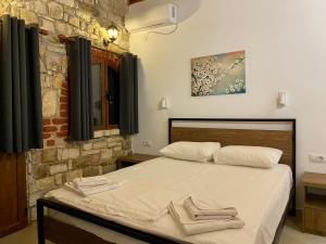 a bedroom with a bed with two towels on it at Itaka Hotel Lukova in Lukovë