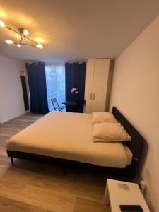 een slaapkamer met een groot bed met blauwe gordijnen bij Le Local DesTiercelins in Nancy +5 foto's