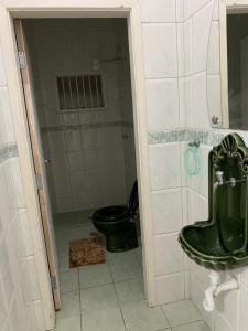 a bathroom with a toilet and a green sink at ESPAÇO guaru in Guarujá