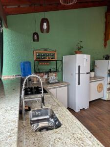 a kitchen with a sink and white appliances at Casa Centro Pocos de Caldas in Poços de Caldas +21 photos