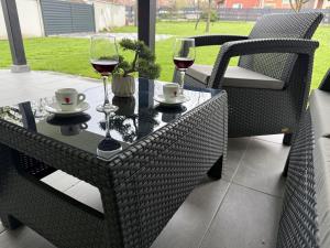 a table with two glasses of wine on a patio at Apartman 28 in Arandelovac