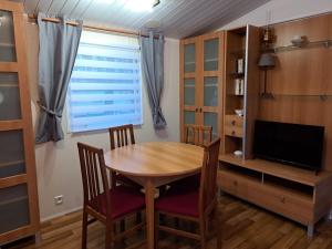 a dining room with a table and chairs and a television at Tin in Marcilly-sur-Eure