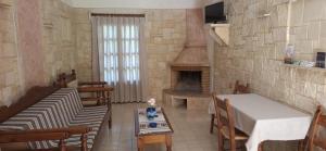 a living room with a fireplace and a table and chairs at Mountain Vista Resort in Roústika
