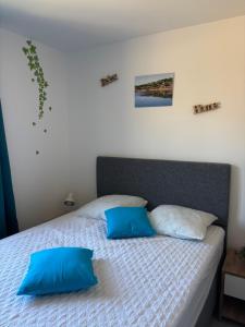a bedroom with a bed with two blue pillows at Alizo in Lecci