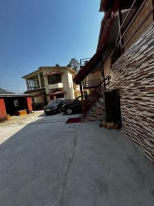 a dog laying on the ground next to a building at Nal Damyanti Homestay in Bhīm Tāl +2 photos