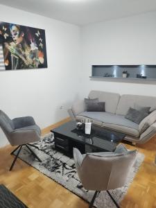 a living room with a couch and a table and chairs at Lena Exclusive in Bihać