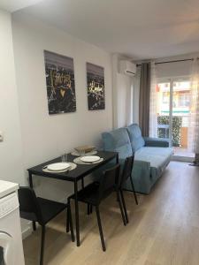 salon ze stołem i kanapą w obiekcie Ágata Benalmádena w mieście Benalmádena