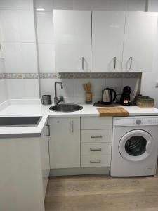 biała kuchnia ze zlewem i pralką w obiekcie Ágata Benalmádena w mieście Benalmádena