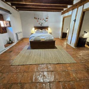 a large bedroom with a bed and a rug at Casa Rural Kristina 2 Estrellas in Retuerta