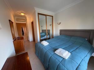 a bedroom with a blue bed with two towels on it at Fairviews Boavista , Boavista golf and spa resort Lagos in Lagos