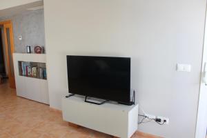 un téléviseur à écran plat posé sur un centre de divertissement blanc dans l'établissement Apto en Cullera con terraza, piscina, parking y wifi gratis, à Cullera 54 autres photos
