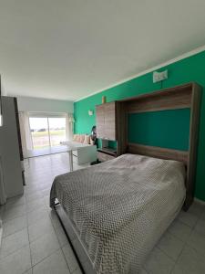 a bedroom with a bed and a green wall at Departamento Cataluña Vista al Mar in Mar del Plata