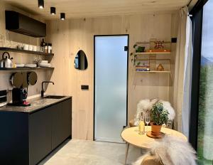 a kitchen with a table and a glass door at Glimre Romsdal - Eksklusivt speilhus ved Åndalsnes in Isfjorden