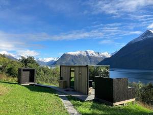 a cabin with a view of a lake and mountains at Glimre Romsdal - Eksklusivt speilhus ved Åndalsnes in Isfjorden