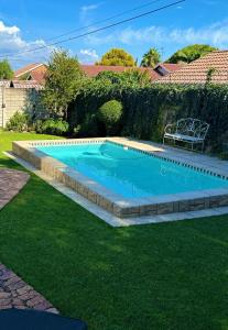 ein Schwimmbecken mit einer Bank im Garten in der Unterkunft Antonella's in Edenvale