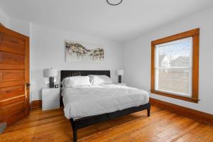 a white bedroom with a bed and a window at Grand Rapids Gem - Near Heart of DT - Sleeps 10 in Grand Rapids