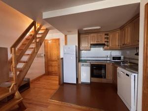 a kitchen with a white refrigerator and wooden cabinets at BPirineos-Senarta in Benasque