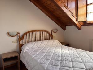 a bedroom with a white bed with a wooden headboard at BPirineos-Senarta in Benasque +7 photos